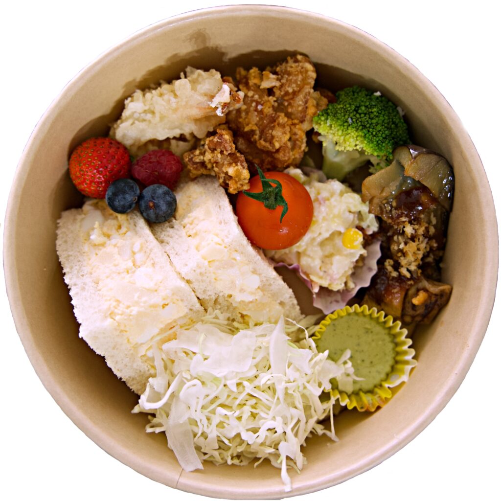 A vibrant and delicious gourmet lunch box featuring a variety of savory and sweet bites, crafted by Colorful Palette Catering.